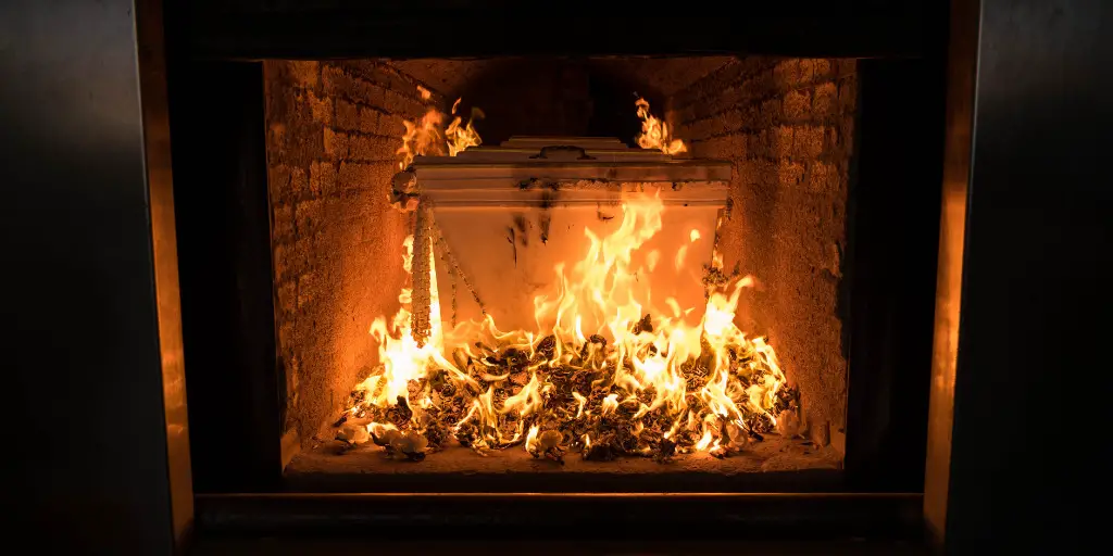 An image of the cremation process. A casket burns.