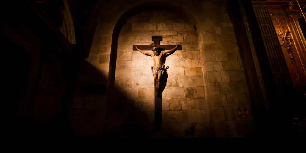 A statue of Jesus on the Cross inside a church building.