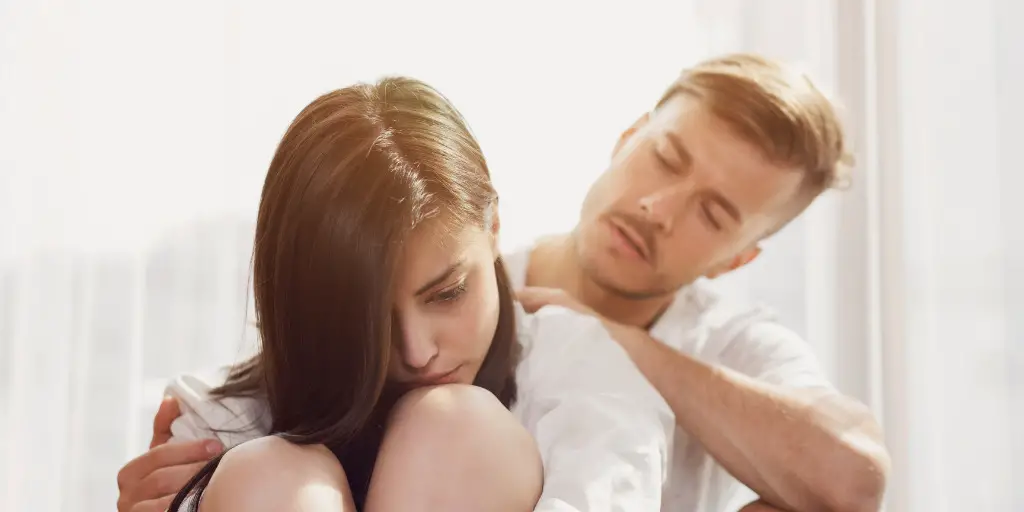 A man comforts a woman who appears to be distressed.